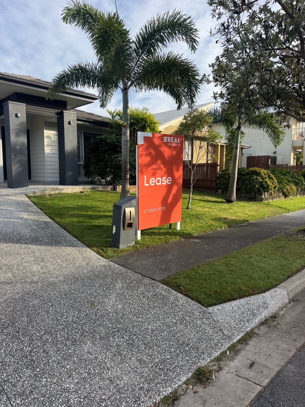Freshly mown front lawn with a real estate lease sign out front