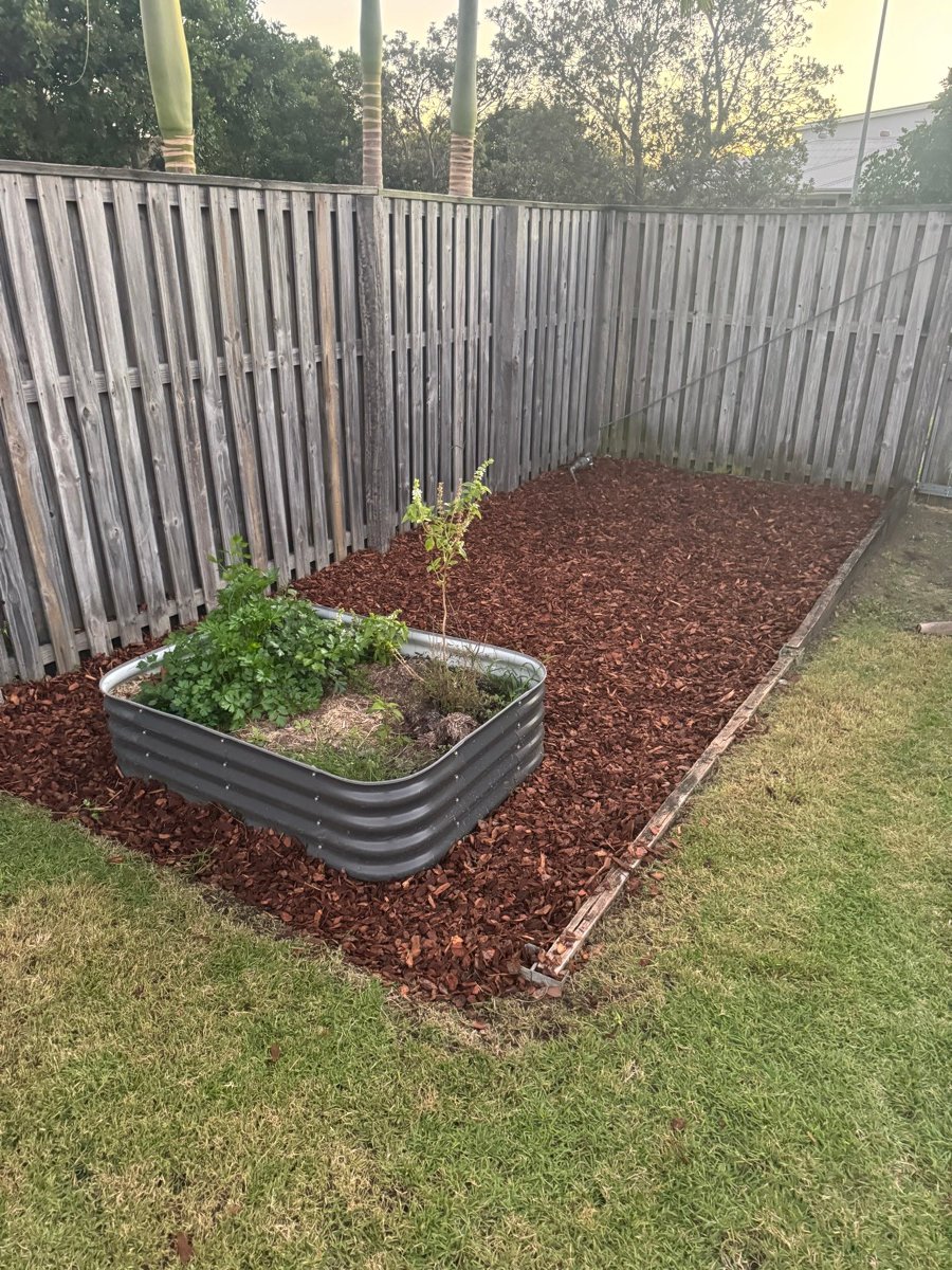The same raised planter box after, cleared and finished with fresh mulch